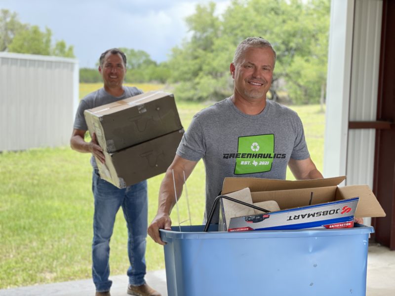 The Greenhaulics team carry junk from a Round Rock home